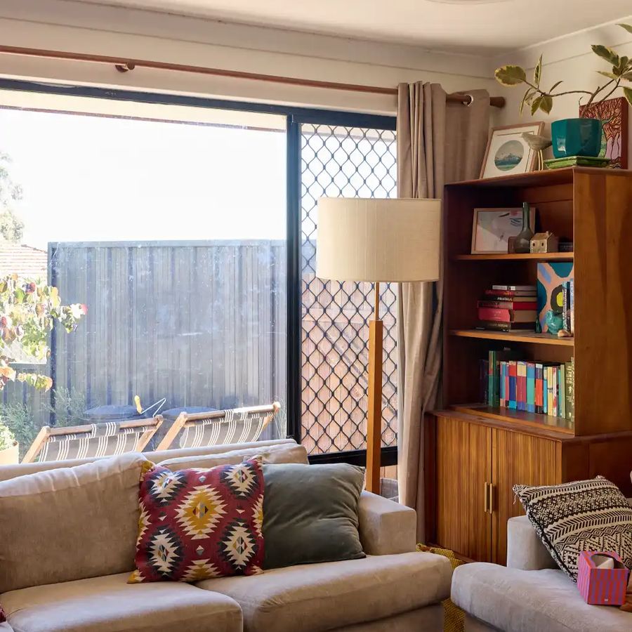 Before: the original dark aluminium sliding door with a diamond security grille, blocking light and views